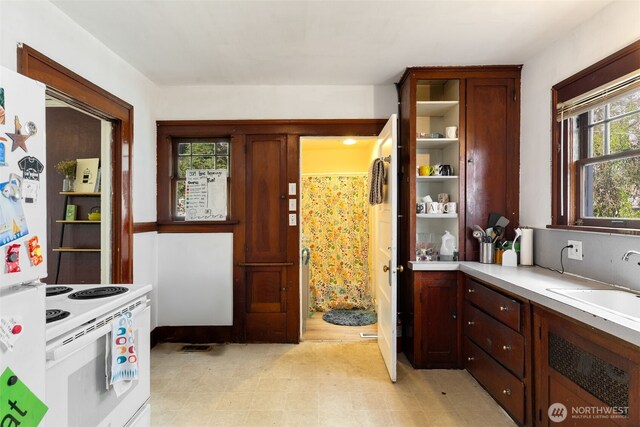 5019 17th Ave NE, Seattle, WA 98105 - kitchen with white appliances, light countertops, open shelves, light floors, and a sink