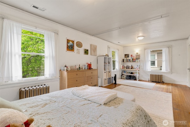 5019 17th Ave NE, Seattle, WA 98105 - bedroom featuring radiator heating unit, visible vents, and wood finished floors