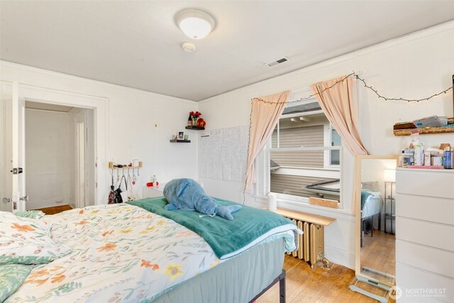 5019 17th Ave NE, Seattle, WA 98105 - bedroom with visible vents, radiator, and wood finished floors
