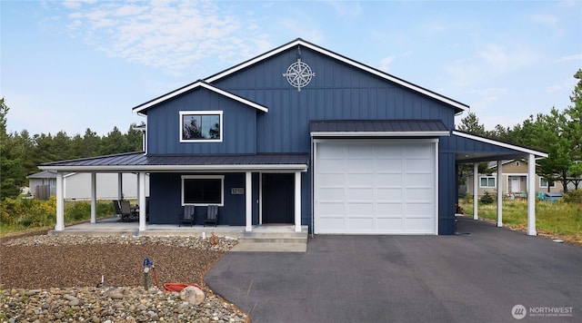 view of front of home with aphalt driveway, a standing seam roof, board and batten siding, metal roof, and a porch