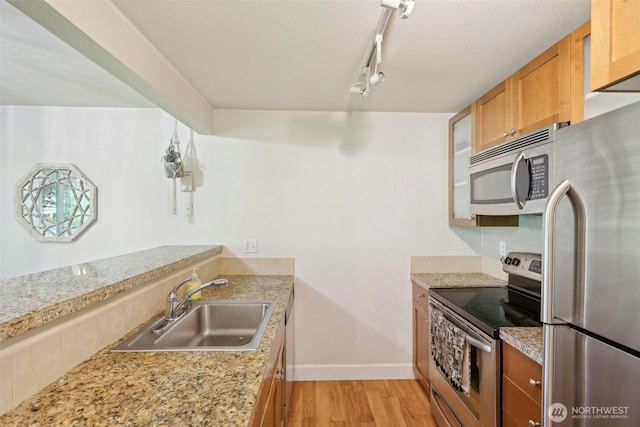 300 N 130th St Unit 8302, Seattle, WA 98133 - kitchen with appliances with stainless steel finishes, a sink, rail lighting, light wood-style floors, and light countertops