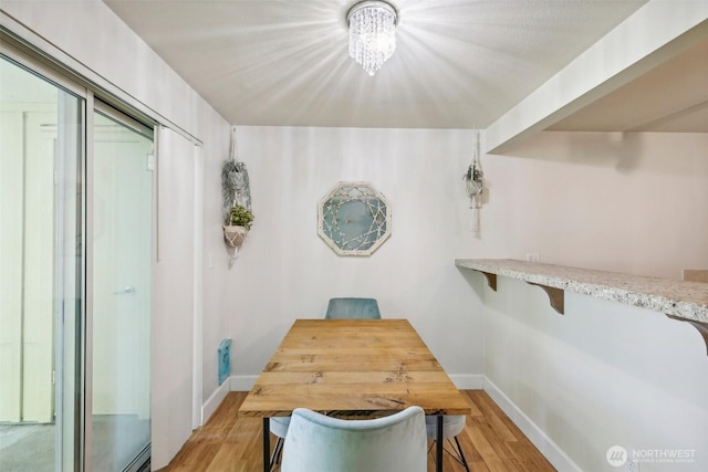 300 N 130th St Unit 8302, Seattle, WA 98133 - dining space with baseboards, light wood finished floors, and a chandelier