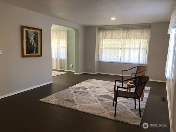 sitting room with arched walkways, baseboards, recessed lighting, and plenty of natural light