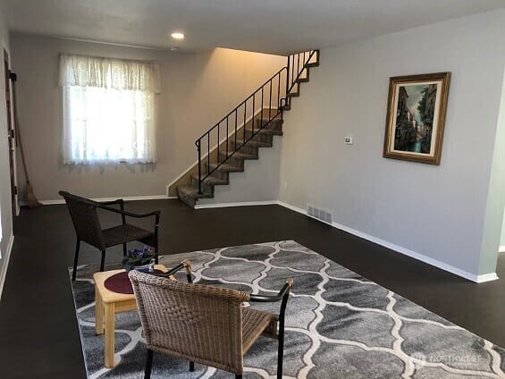 living room featuring visible vents, baseboards, dark wood-style flooring, stairway, and recessed lighting