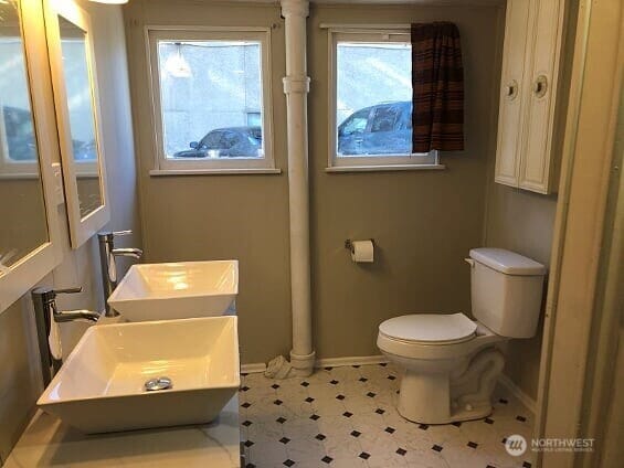 bathroom with toilet, baseboards, and a sink