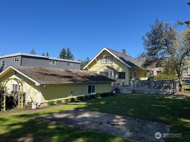 exterior space with a front yard and a wooden deck