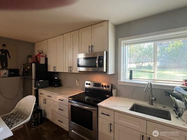 kitchen featuring a sink, white cabinetry, and stainless steel appliances