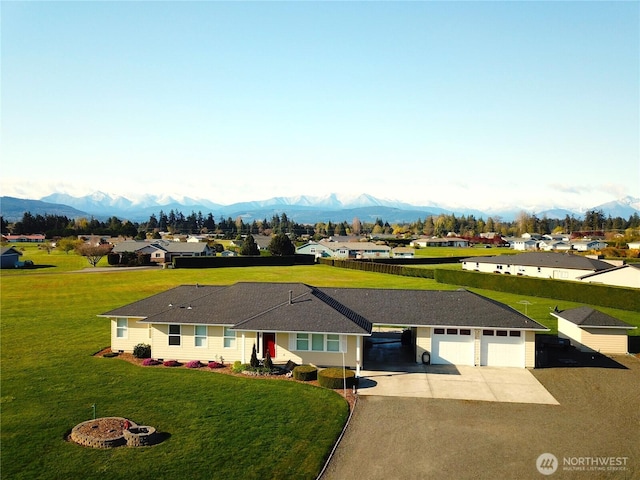 view of front of house with a garage, a front lawn, a mountain view, and concrete driveway