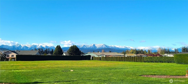 view of yard featuring fence and a mountain view