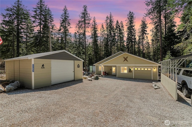 22603 Corral St, Leavenworth, WA 98826 - view of front facade with an outdoor structure, a garage, driveway, and view of wooded area