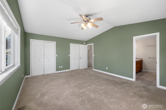 8148 Quinault Rd, Blaine, WA 98230 - unfurnished bedroom with baseboards, vaulted ceiling, light carpet, ensuite bathroom, and two closets