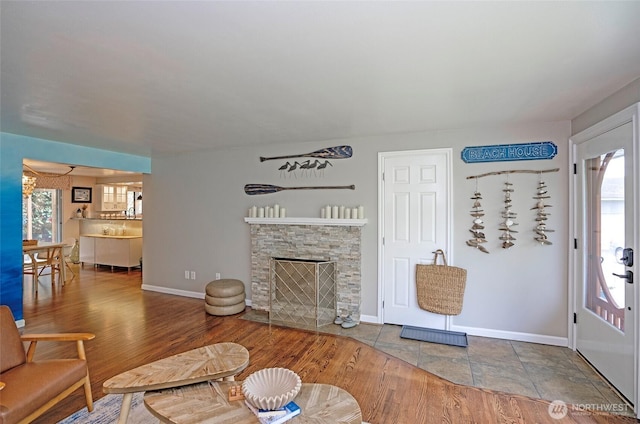 22332 10th Ave S, Des Moines, WA 98198 - living room featuring baseboards, a stone fireplace, and wood finished floors