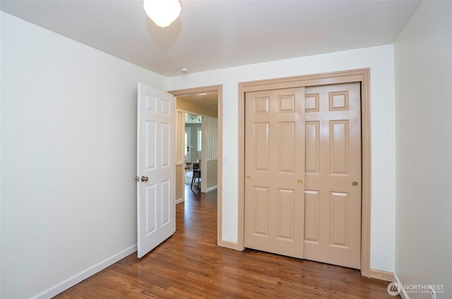 22332 10th Ave S, Des Moines, WA 98198 - unfurnished bedroom featuring wood finished floors, baseboards, and a closet
