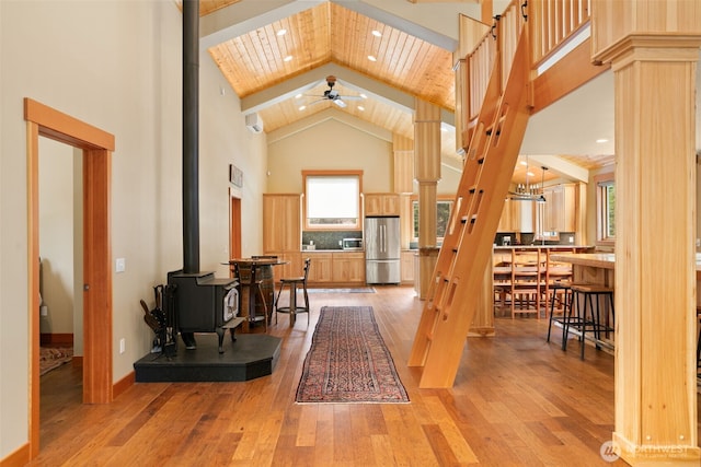 17650 Roaring Creek Rd, Leavenworth, WA 98826 - entryway featuring high vaulted ceiling, a wood stove, a wealth of natural light, a ceiling fan, and light wood finished floors