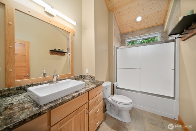 17650 Roaring Creek Rd, Leavenworth, WA 98826 - full bath featuring vanity, stone finish flooring, toilet, wooden ceiling, and bath / shower combo with glass door