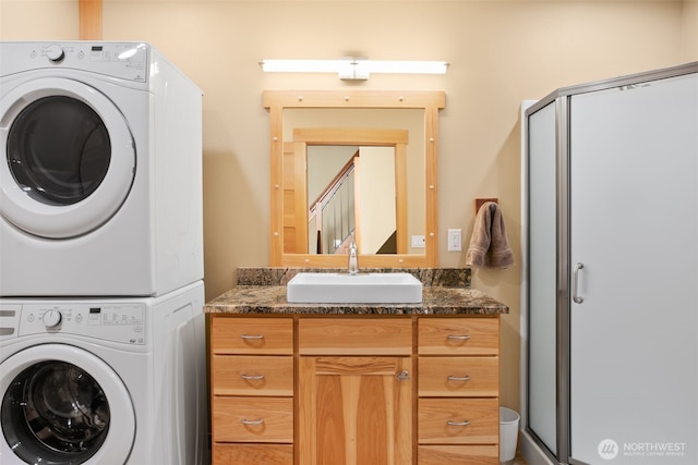 17650 Roaring Creek Rd, Leavenworth, WA 98826 - laundry area featuring a sink, stacked washer and clothes dryer, and cabinet space