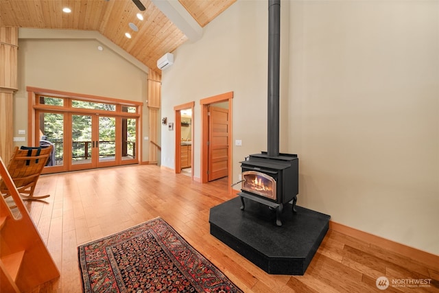 17650 Roaring Creek Rd, Leavenworth, WA 98826 - living area with high vaulted ceiling, a wood stove, light wood-type flooring, wooden ceiling, and a wall mounted air conditioner