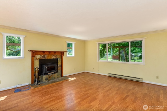 4109 S Reddick Rd, Port Angeles, WA 98363 - unfurnished living room with baseboard heating, ornamental molding, wood finished floors, plenty of natural light, and a wood stove