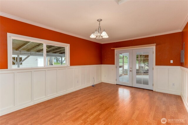 4109 S Reddick Rd, Port Angeles, WA 98363 - spare room featuring a decorative wall, french doors, a chandelier, crown molding, and light wood-type flooring