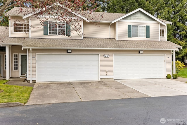 view of front of house with a garage, driveway, and a shingled roof