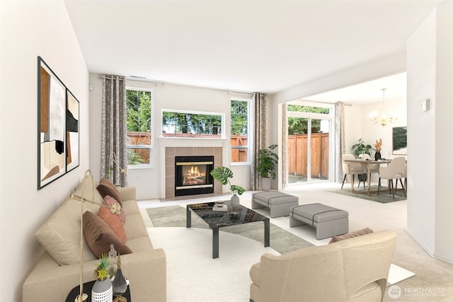 carpeted living room featuring a fireplace, a notable chandelier, and a wealth of natural light