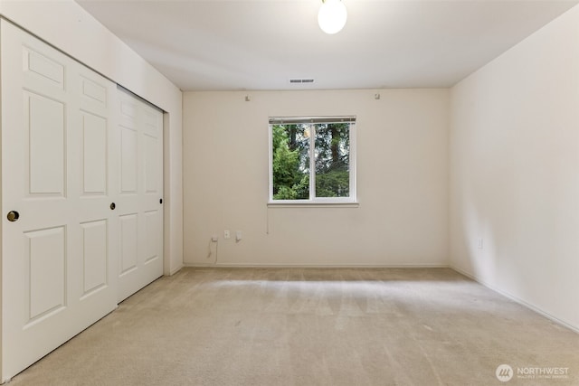 unfurnished bedroom featuring carpet flooring, visible vents, a closet, and baseboards