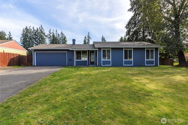 ranch-style home featuring driveway, a garage, fence, and a front yard