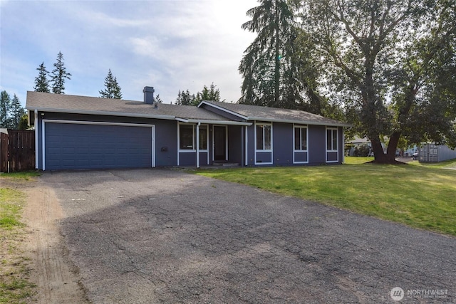 ranch-style home featuring a front yard, an attached garage, a chimney, fence, and driveway