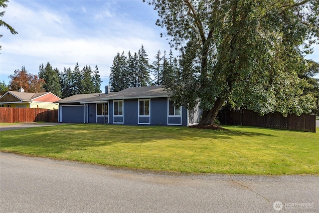 single story home featuring a front yard, fence, an attached garage, a chimney, and driveway