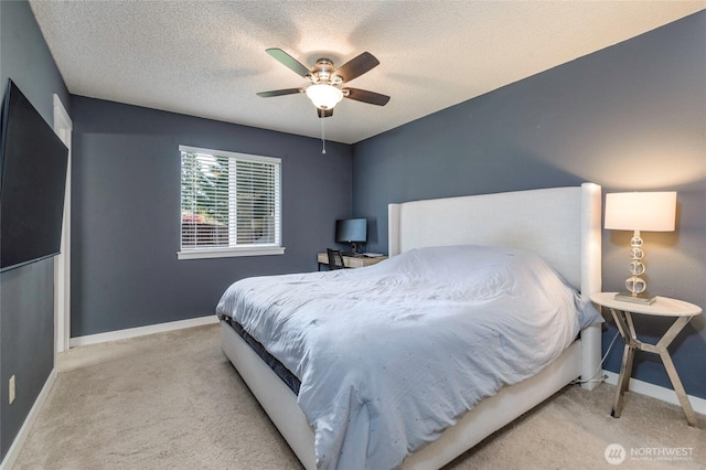 bedroom with a textured ceiling, ceiling fan, baseboards, and carpet floors