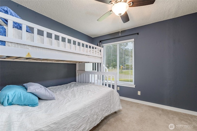 carpeted bedroom with baseboards, a textured ceiling, and ceiling fan