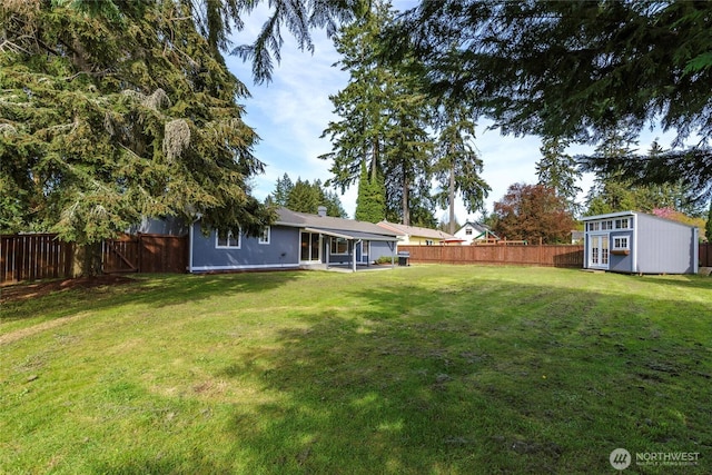 view of yard featuring a storage shed, a fenced backyard, and an outdoor structure