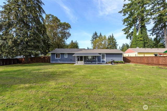 back of house with a patio, a yard, and a fenced backyard