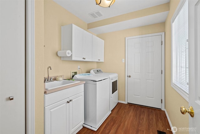 laundry room with a sink, plenty of natural light, visible vents, independent washer and dryer, and cabinet space