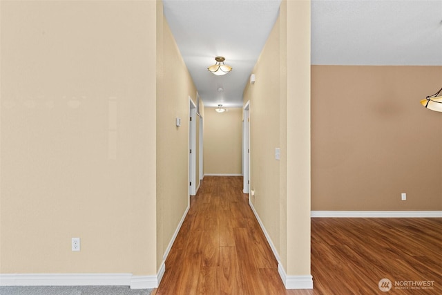 hall featuring wood finished floors and baseboards