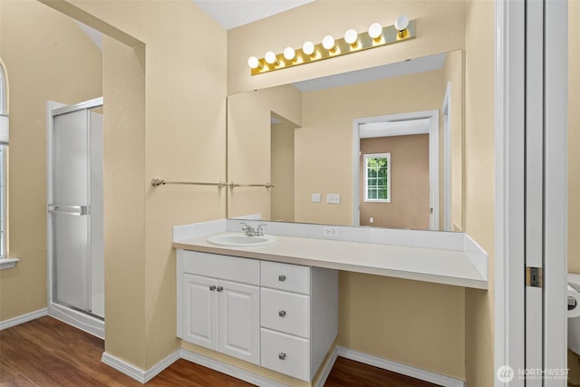 full bathroom with baseboards, a shower stall, wood finished floors, and vanity