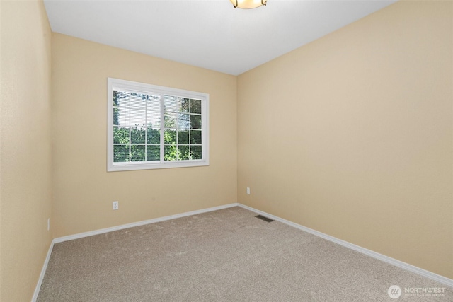 carpeted empty room with visible vents and baseboards