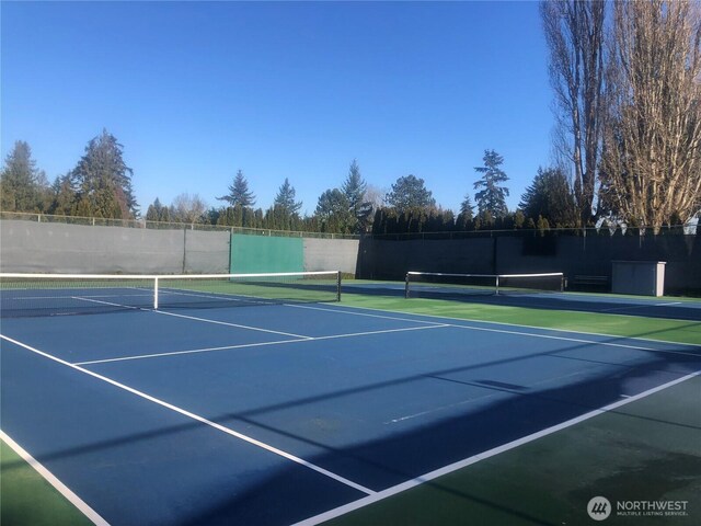 view of tennis court with fence and community basketball court