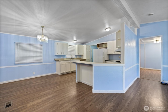 kitchen featuring a chandelier, freestanding refrigerator, a sink, and dark wood-style flooring