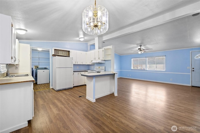 kitchen featuring white appliances, white cabinetry, under cabinet range hood, dark wood-style flooring, and a sink
