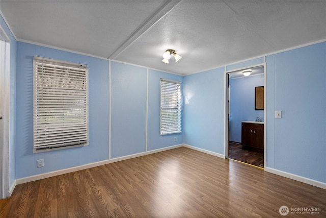 spare room with wood finished floors and baseboards