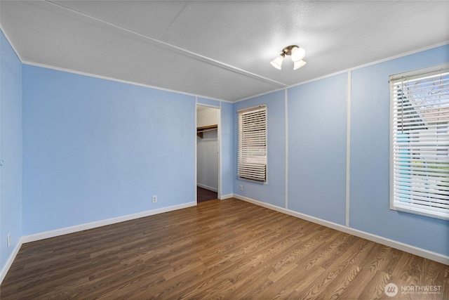 unfurnished bedroom with crown molding, wood finished floors, and baseboards
