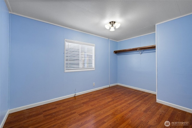 unfurnished bedroom with crown molding, wood finished floors, and baseboards