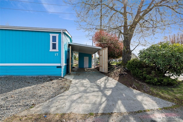 view of side of property with an attached carport and driveway