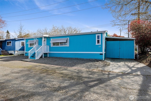 view of front of home featuring an attached carport and driveway