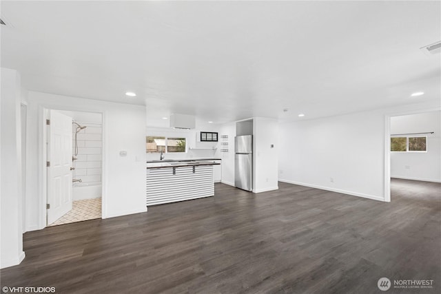 1210 Madison St, Aberdeen, WA 98520 - unfurnished living room featuring dark wood-type flooring, baseboards, and recessed lighting