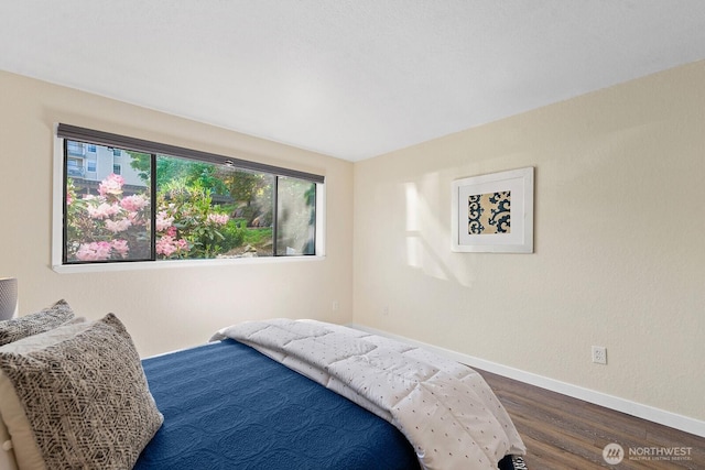 bedroom with baseboards and dark wood-style flooring