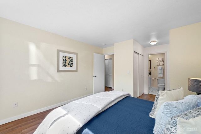 bedroom with ensuite bath, baseboards, and wood finished floors