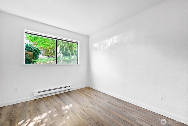 empty room with a baseboard radiator, baseboards, and wood finished floors