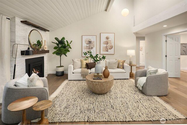 11820 NE 145th St, Kirkland, WA 98034 - living room with high vaulted ceiling, wood finished floors, a fireplace, baseboards, and beam ceiling